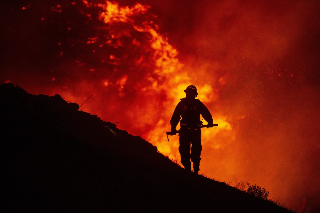 A firefighter works at containing a wildfire as it spreads in the hills near homes in Chino Hills, California in September. Photo: EPA-EFE