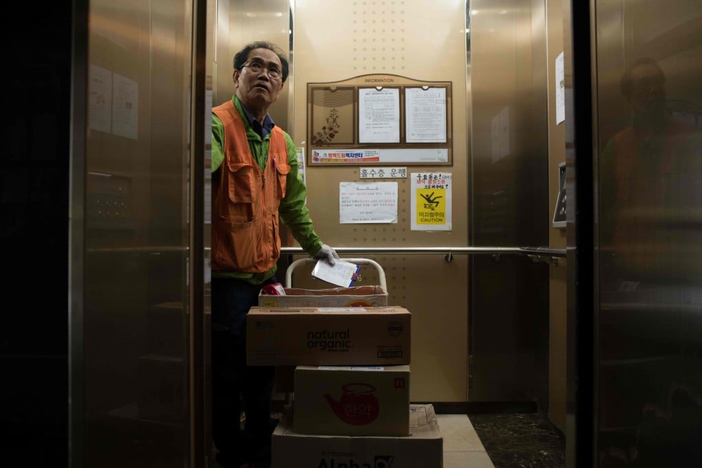 A 71-year-old delivery man enters an elevator in Seoul to deliver packages to high-rise apartments in this 2018 file photo. Photo: AFP