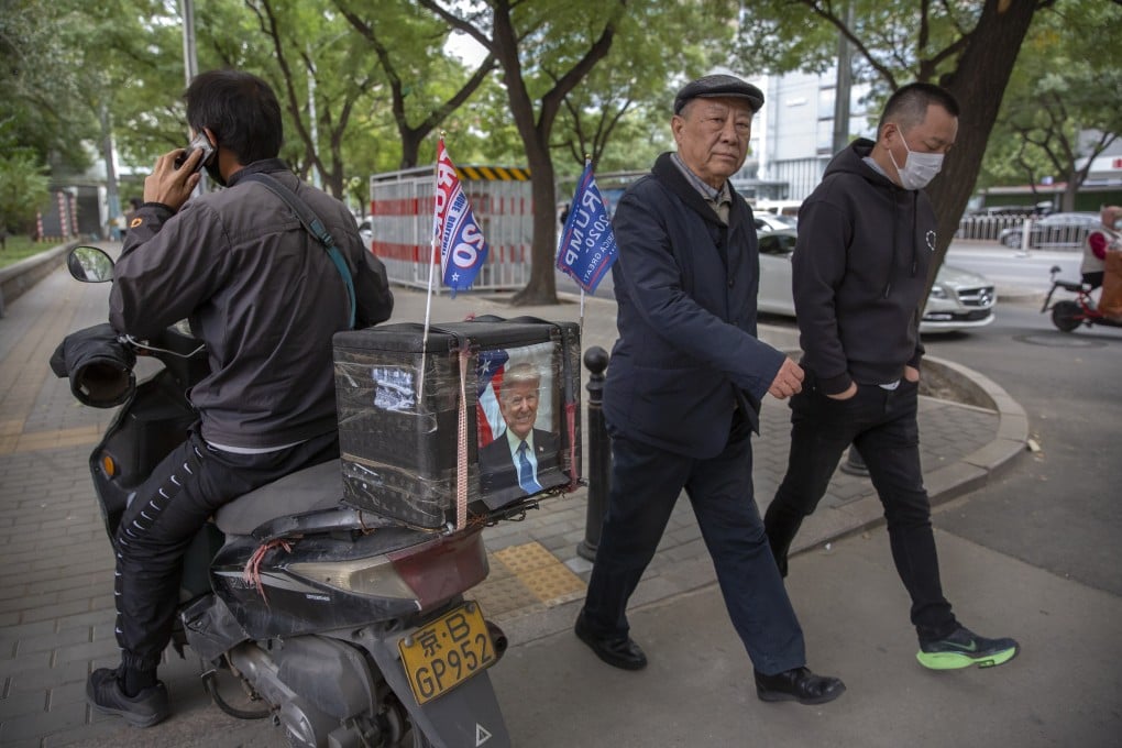 A delivery courier rides a motorbike decorated with a portrait of US President Donald Trump and “Trump 2020” flags in Beijing on Wednesday. Photo: AP