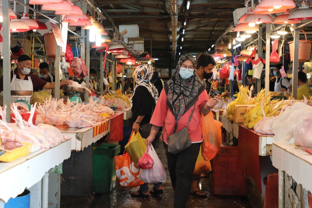 People wearing protective masks shop at a market in Kuala Lumpur, Malaysia. Photo: Reuters