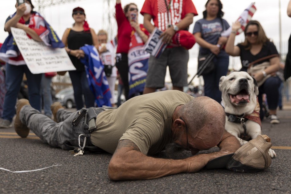 A Donald Trump supporter prays during a protest in front of the Maricopa County Tabulation and Election Centre in Phoenix as the counting of ballots continues amid the still contested US presidential election. Photo: DPA