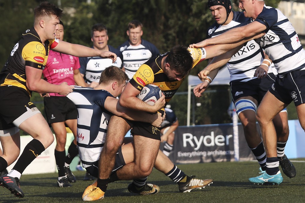 Borrelli Walsh USRC Tigers’ Charlie Wilson gets tackled by men’s Premiership title-holders Natixis Hong Kong Football Club on Saturday. Photo: SCMP/Xiaomei Chen