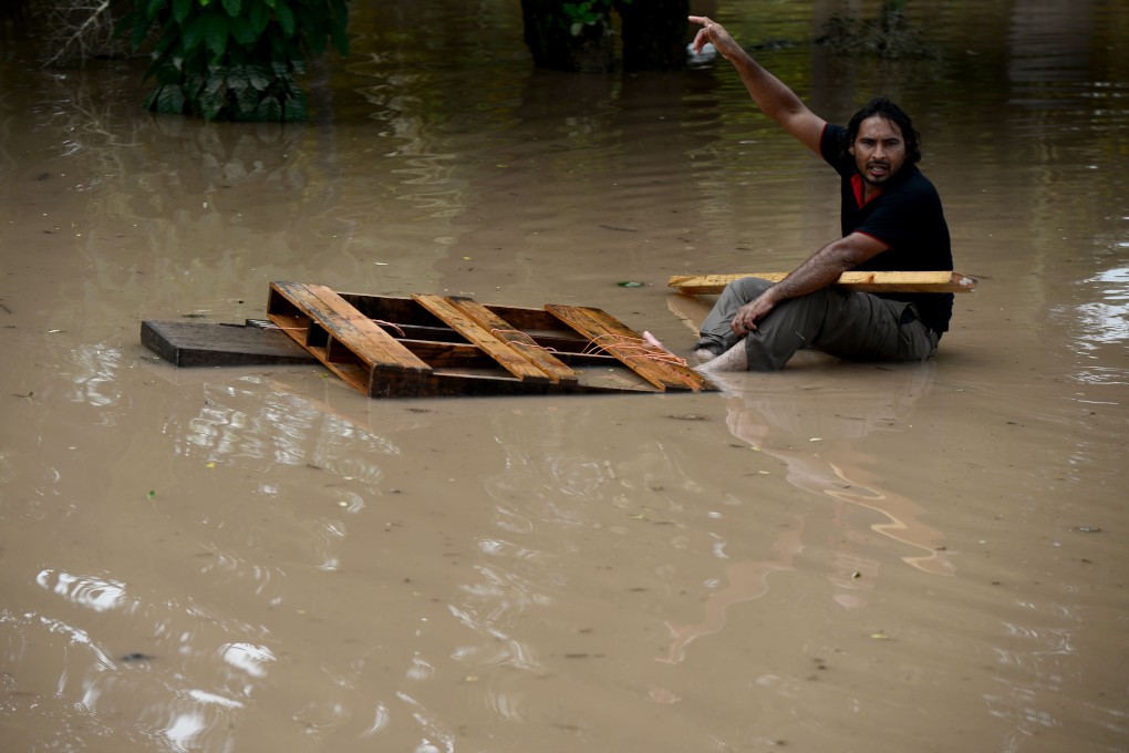 A man gestures at a flooded street in Omonita, El Progreso municipality, Yoro department, Honduras, on Friday. Photo: AFP