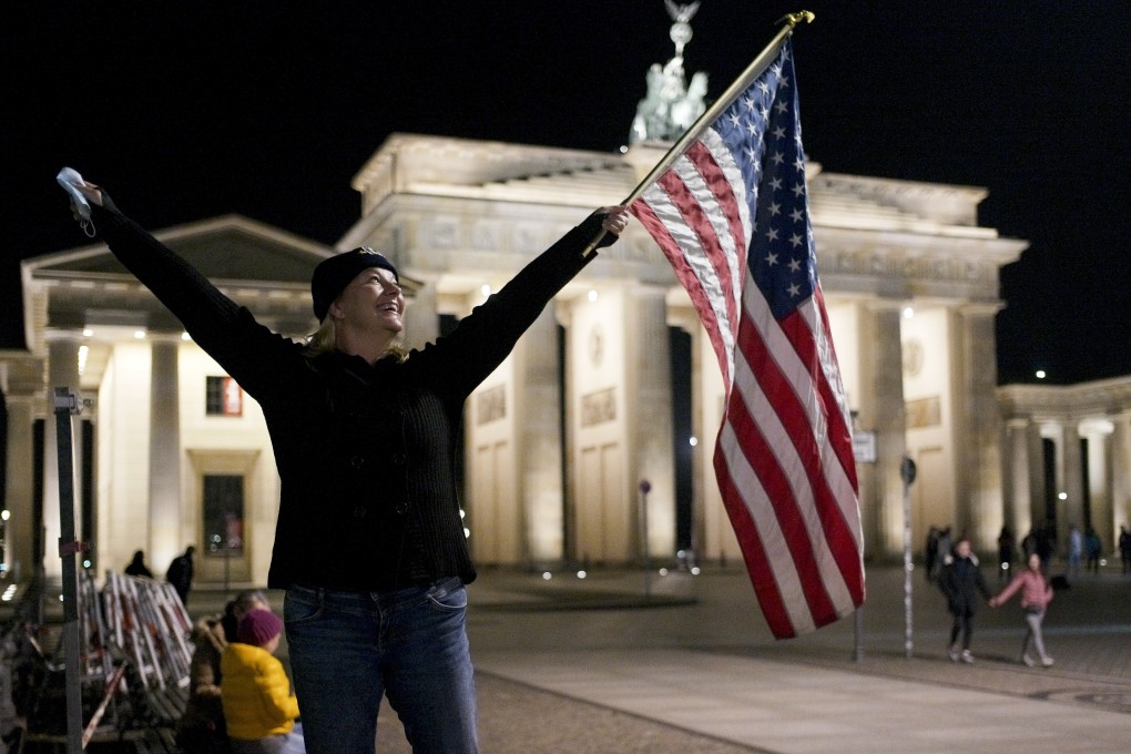 Marianne Hoenow from Connecticut in the US celebrates the victory of President-elect Joe Biden and Vice President-elect Kamala Harris in Berlin, Germany. Photo: AP