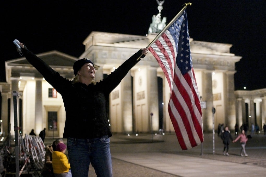 Marianne Hoenow from Connecticut in the US celebrates the victory of President-elect Joe Biden and Vice President-elect Kamala Harris in Berlin, Germany. Photo: AP