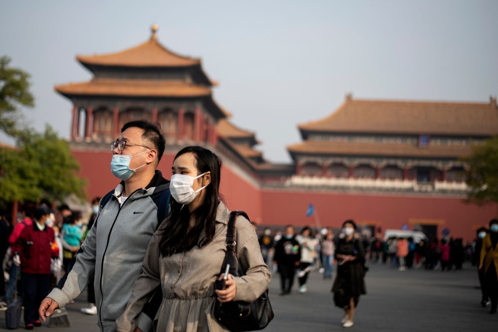 People wearing face masks walk outside Beijing’s Forbidden City during the country's ‘golden week’, on October 8. Photo: AFP