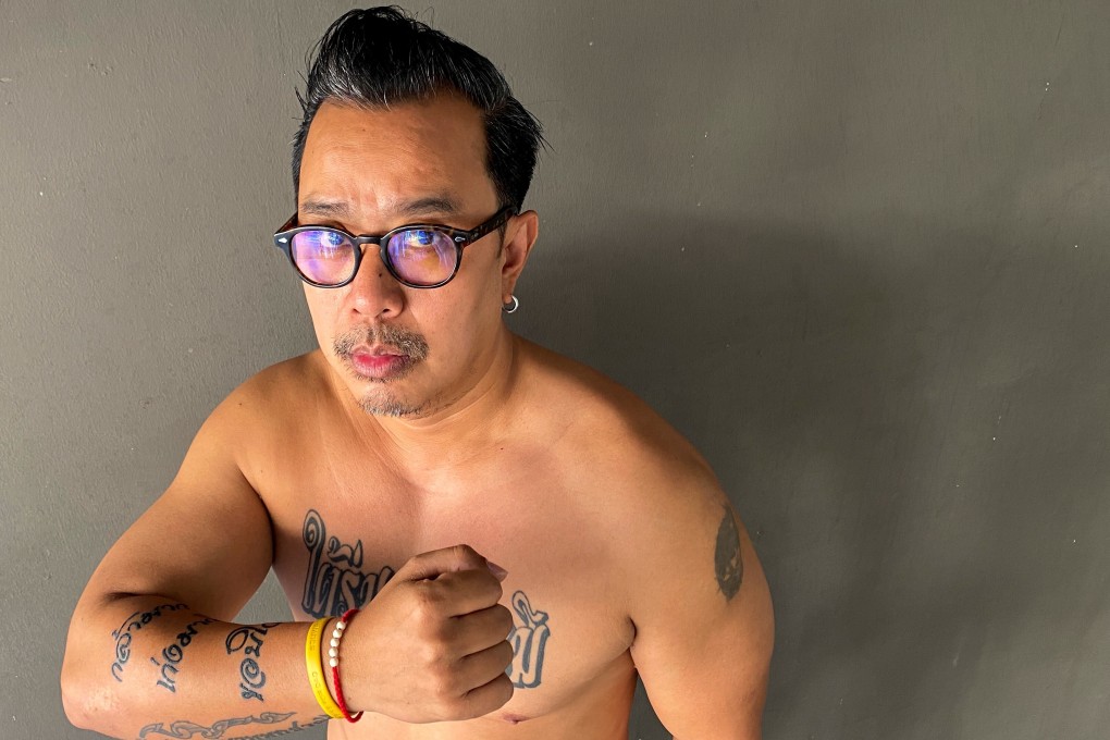 Thai royalist Thitiwat Tanagaroon, whom King Maha Vajiralongkorn and Queen Suthida praised for holding a royal portrait at an anti-government protest, shows his arm tattoos reading 'Very brave, very good, thank you'. Photo: Reuters