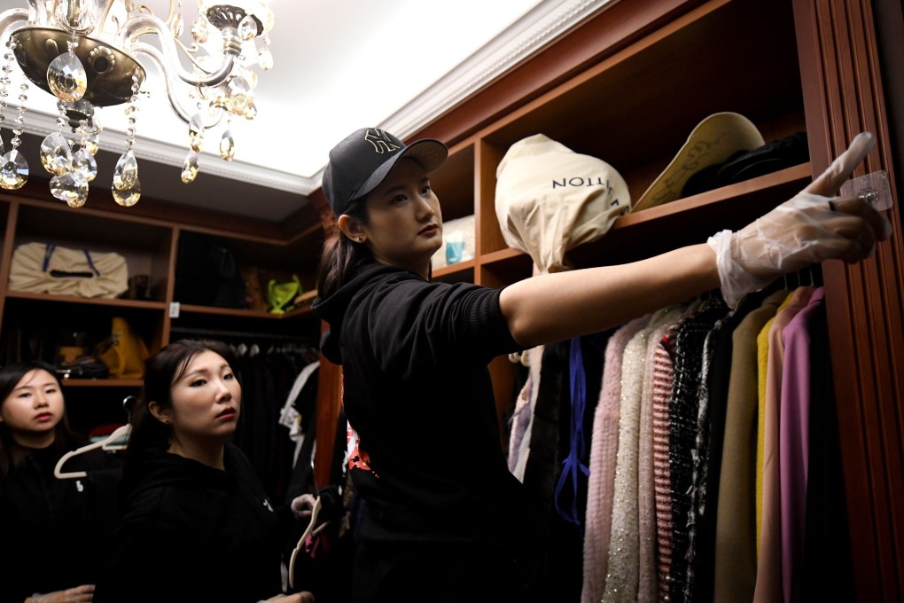 A team of home organisers tidy the luxury wardrobe of a client in Beijing. Photo: AFP