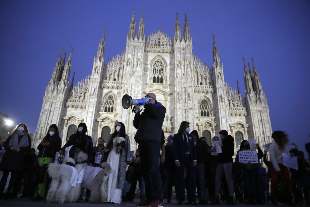 Shop owners and workers stage an anti-coronavirus in front of the Milan cathedral, Italy. Photo: AP