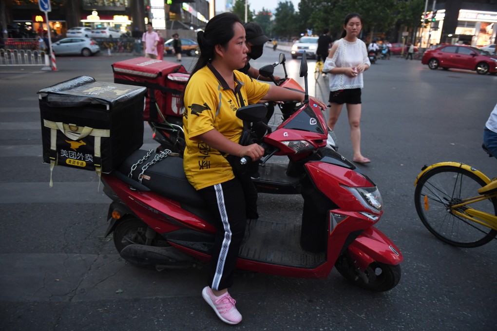 A Meituan delivery rider waits at an intersection in Beijing. Photo: AFP