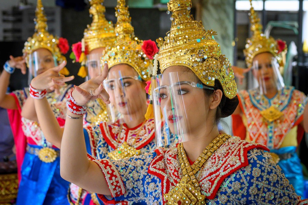 Traditional Thai dancers wearing protective face shields perform at the Erawan Shrine in Bangkok, a major tourist destination. As Thailand’s tourism sector has taken a financial hit from the coronavirus pandemic, the government has been trying to shore up trade ties with other countries to make up for lost revenue. Photo: AFP