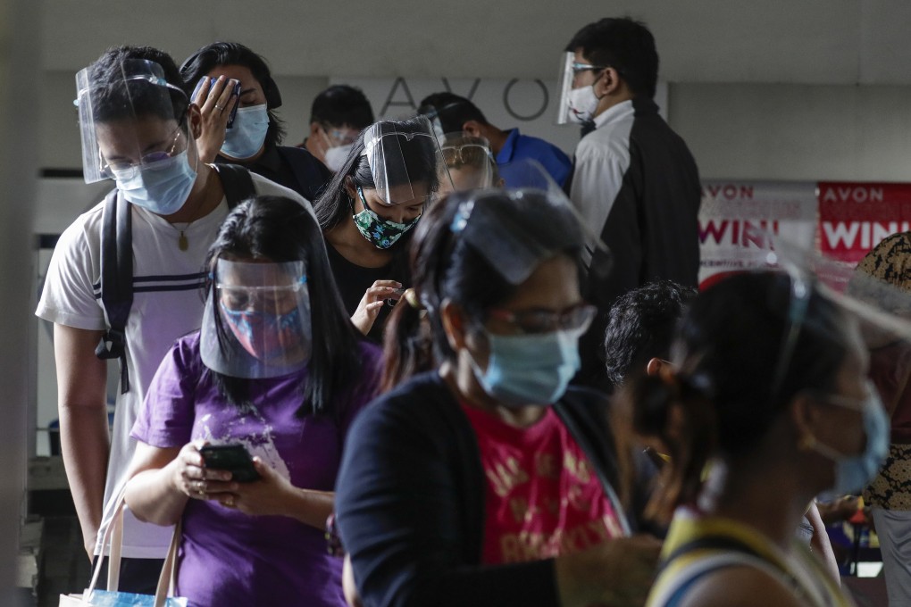 Filipinos in personal protective gear wait to enter a government office in Quezon City. The country has recorded more than 400,000 cases of the coronavirus. Photo: AP