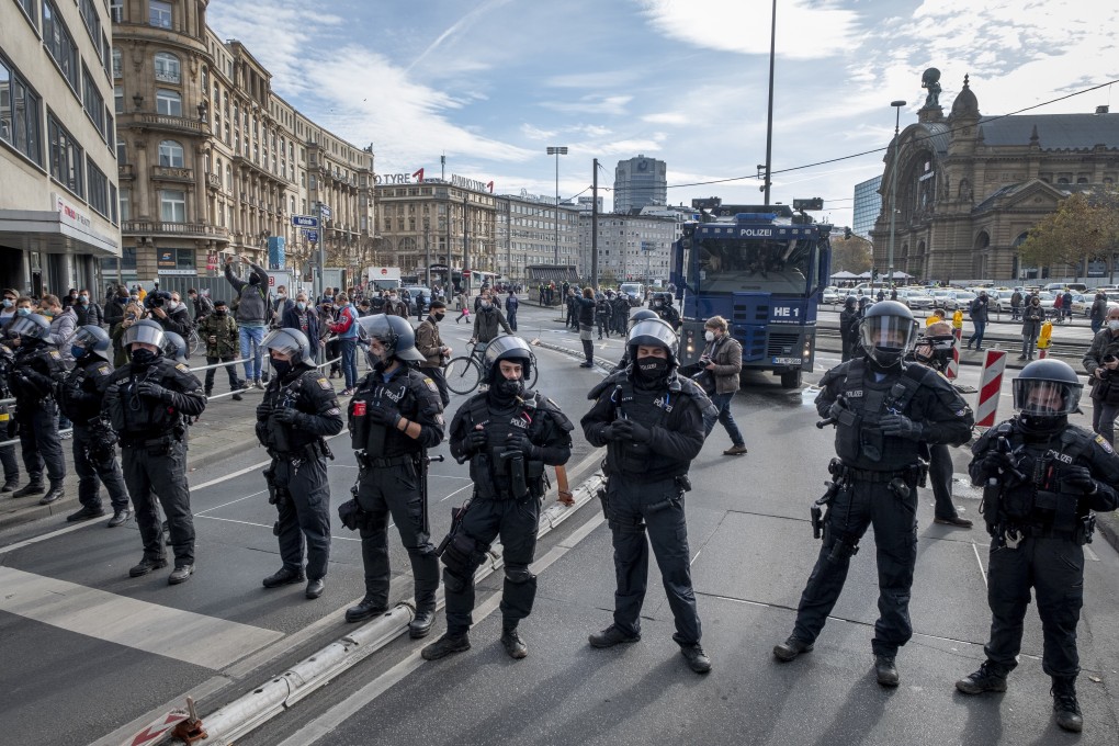 Police officers stand guard during an anti-lockdown rally in Frankfurt, Germany, on Saturday. Photo: AP