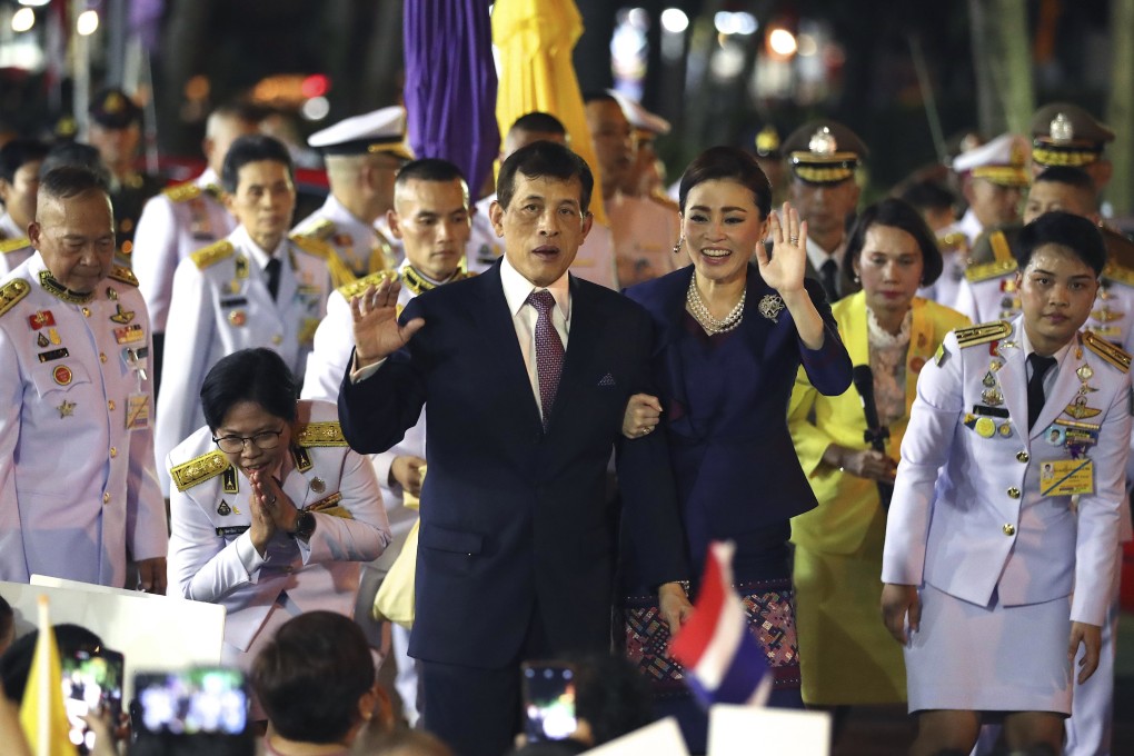 Thai King Maha Vajiralongkorn, left and Queen Suthida, right, wave to supporters in Bangkok, Thailand on Saturday. Photo: AP