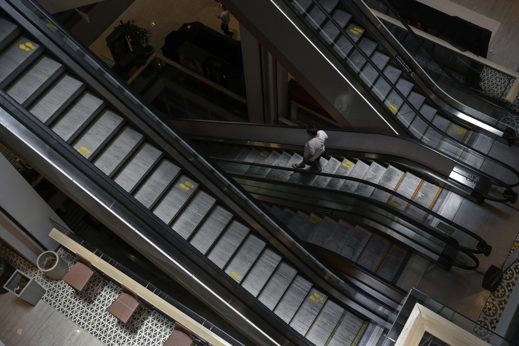An elderly man wearing a protective mask rides an escalator inside an empty shopping centre in Quezon City, Manila in May during a lockdown. Photo: AP
