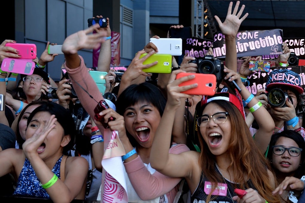 American fans of Korean K-pop group Girl's Generation scream as they appear on the red carpet during K-CON 2014 at the Los Angeles Memorial Sports Arena. The group’s fandom, Sone, is one of many whose members obsessively follow K-pop idols. Photo: AFP