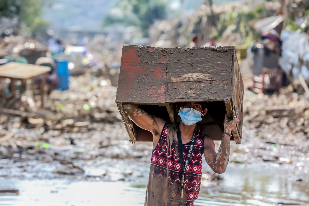A man retrieves his belongings from his flooded home in Rizal Province, the Philippines, on Saturday. Photo: Xinhua