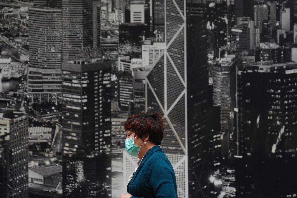 An office worker walks past a poster of the Hong Kong skyline, in North Point on April 2. Even after two decades, the MPF scheme has yet to be seen as a useful pillar of retirement protection. Photo: Sam Tsang