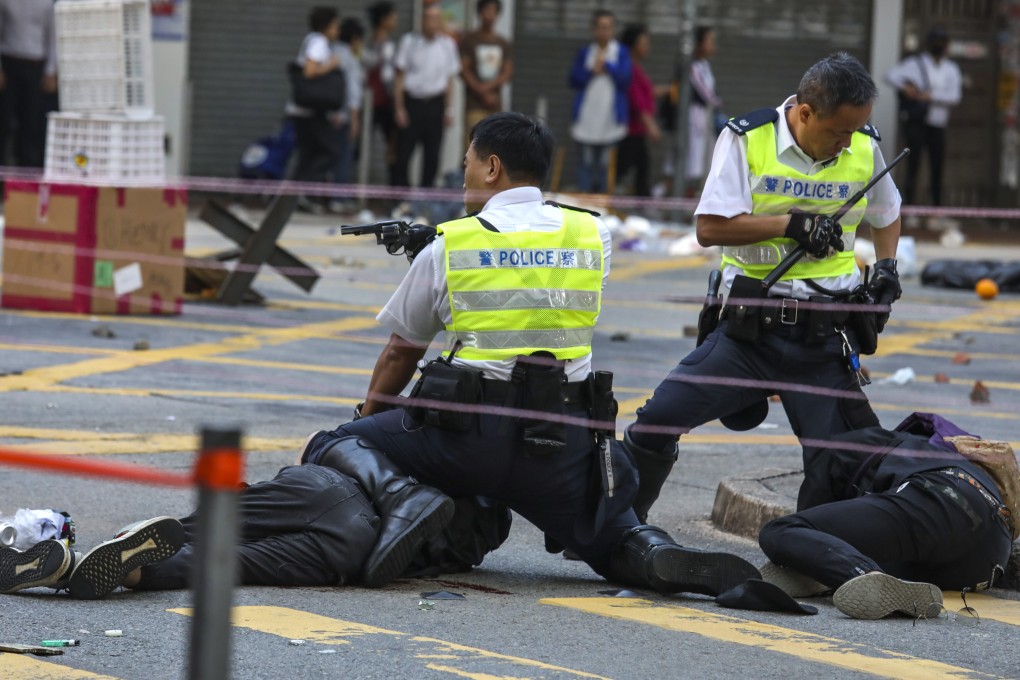 Police officers subdue protesters blocking a road crossing in Sai Wan Ho on November 11, 2019. Photo: Nora Tam