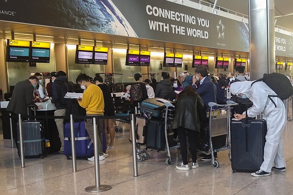 Cathay Pacific check-in desks at London’s Heathrow Airport with a traveller in full hazmat garb. The imposition of a month-long lockdown in England prompted more than the usual number of travellers to take a flight to Hong Kong before restrictions were imposed. Photo: Tim Pile