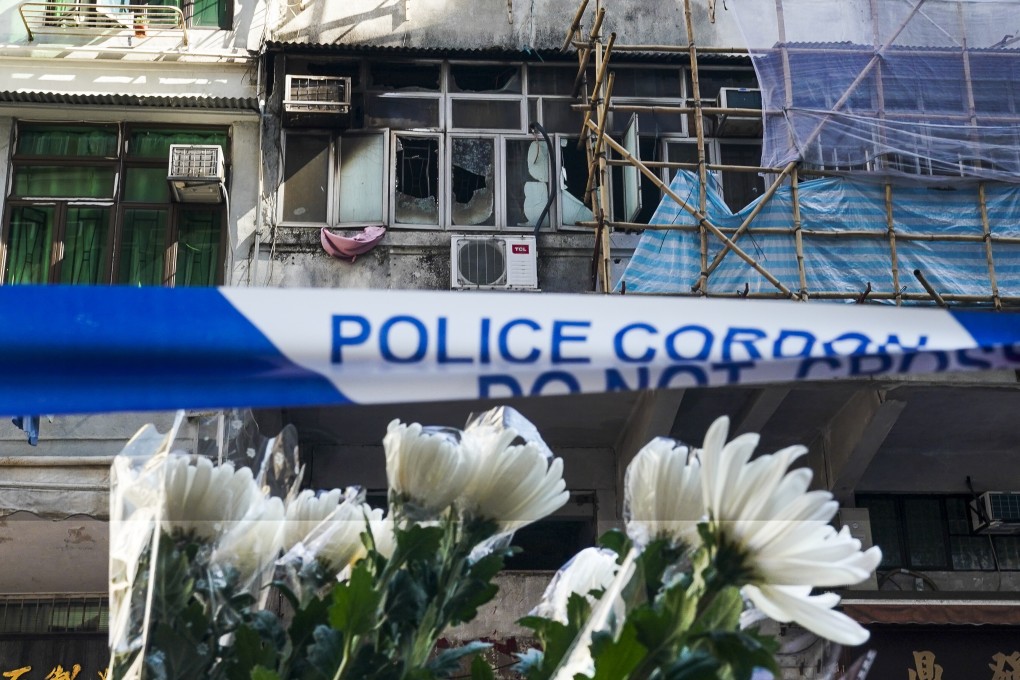 Flowers left in tribute to the victims of the fire in a tenement building in Yau Ma Tei on Sunday. Photo: Felix Wong