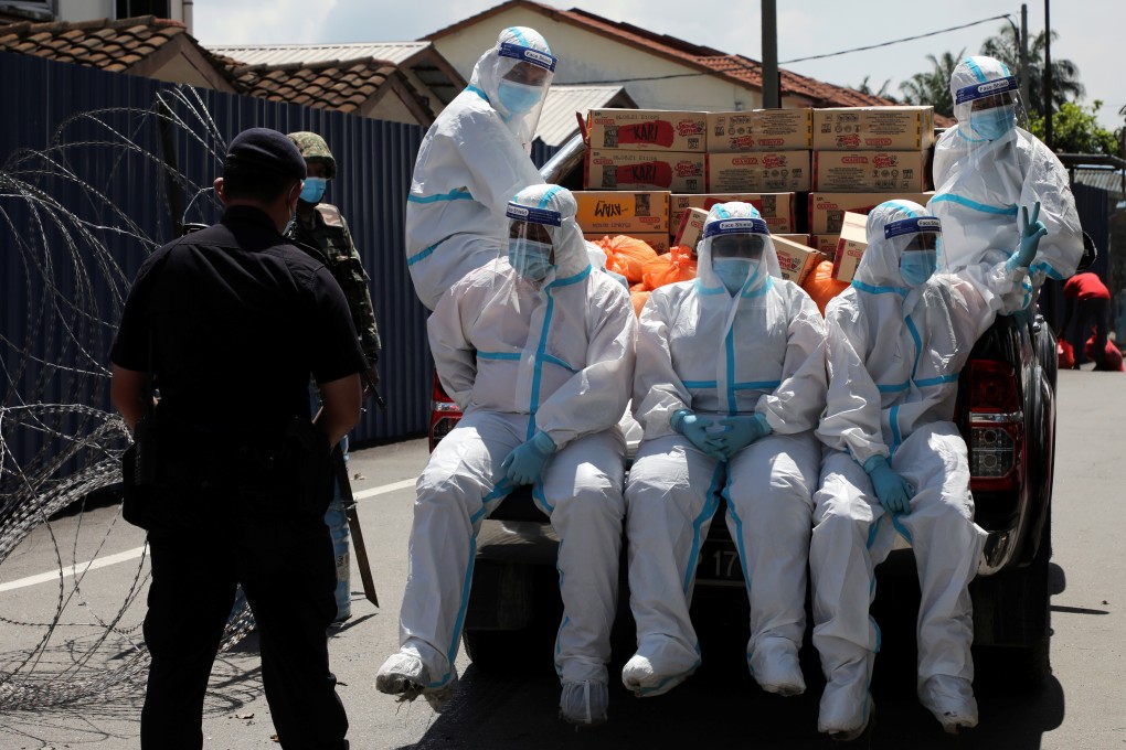 Members of Malaysia Social Welfare Department wearing personal protective equipment prepare for food distribution at an area under enhanced lockdown. Photo: Reuters