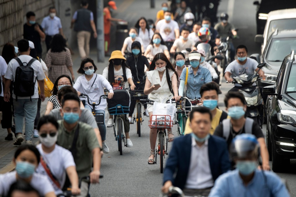 A woman checks her phone among cyclists on a busy street in Beijing on July 20. A growing number of Chinese people are unmarried. Photo: AFP