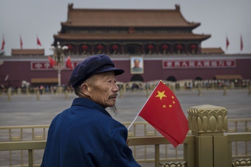A man holds a flag in Tiananmen Square, in Beijing, on October 1, 2014. Photo: Getty Images