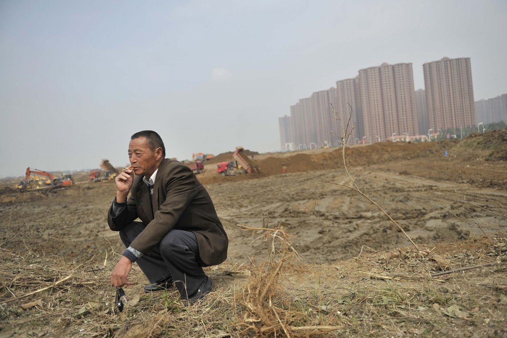 A farmer smokes as some buildings on his land are demolished to make way for the construction of new urban property in Hefei, southeast Anhui province. Land reform remains an important issue on the mainland, one for which Hong Kong’s legal system can provide a template. Photo: Reuters