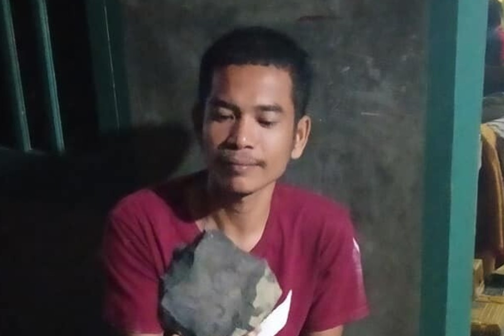 Josua Hutagalung and the meteorite that crashed into his house in North Sumatra. Photo: Handout