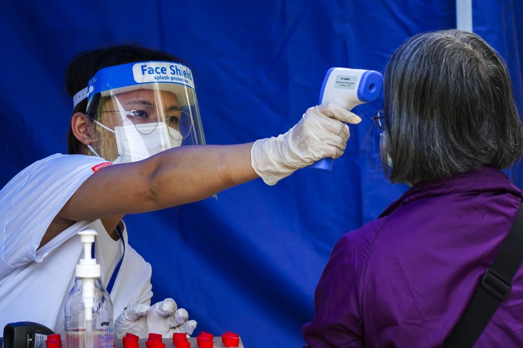 A medical worker takes the temperature of a Hong Kong resident before Covid-19 testing on November 9. Photo: Sam Tsang