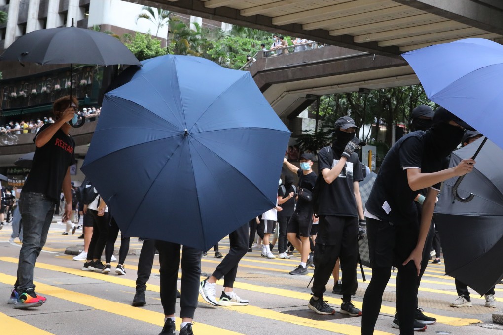 Anti-government protesters opens up their umbrellas to defend themselves as they take over Queen’s Road East during an illegal demonstration on the 23rd anniversary of the establishment of the Hong Kong Special Administrative Region. Photo: K. Y. Cheng