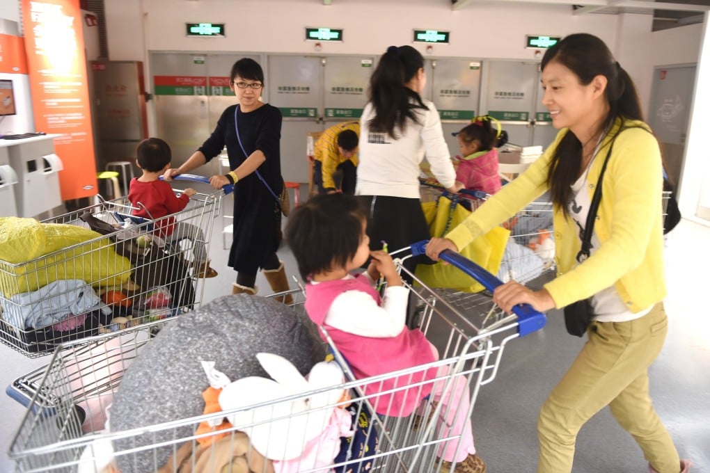A group of Chinese mothers go shopping with their children at a furniture store in Beijing. A survey has highlighted the problems working mothers face in China. Photo: AFP