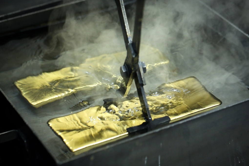 A worker plunges a gold ingot into a cooling bath at the Uralelectromed Copper Refinery, operated by Ural Mining and Metallurgical Co. (UMMC), in Verkhnyaya Pyshma, Russia on July 30, 2020. Photo: Bloomberg