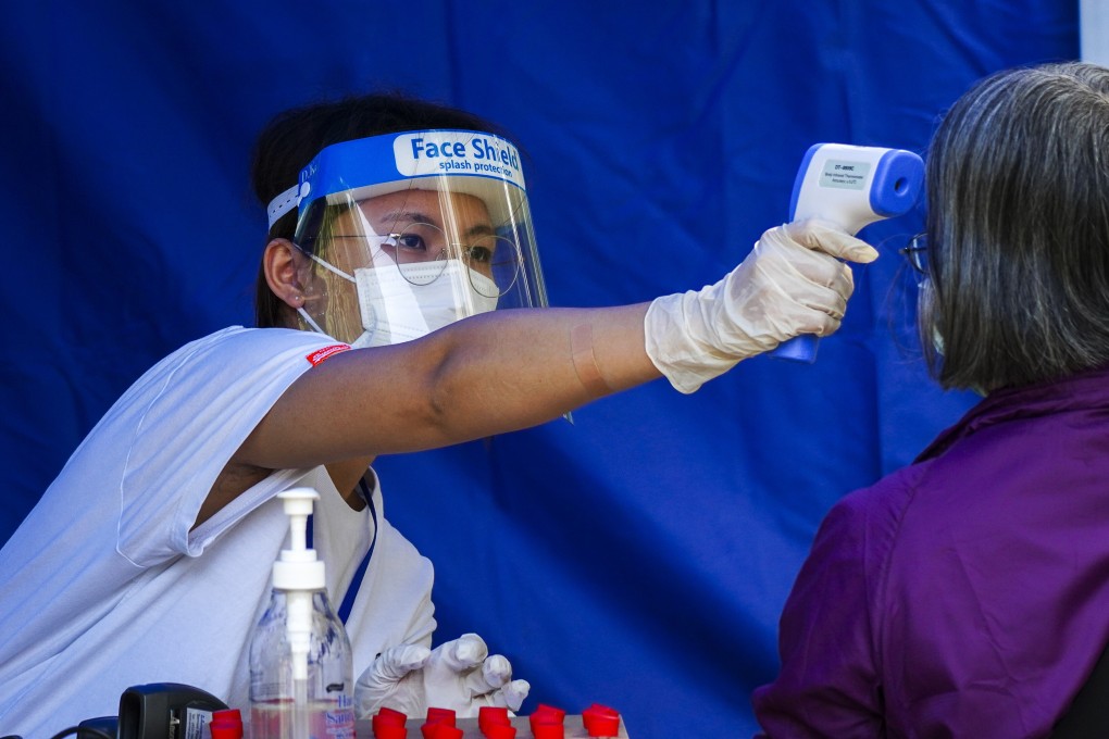 A medical worker takes the temperature of a resident at a temporary Covid-19 testing station outside Fu Shin Community Hall in Tai Po on November 9. Photo: Sam Tsang