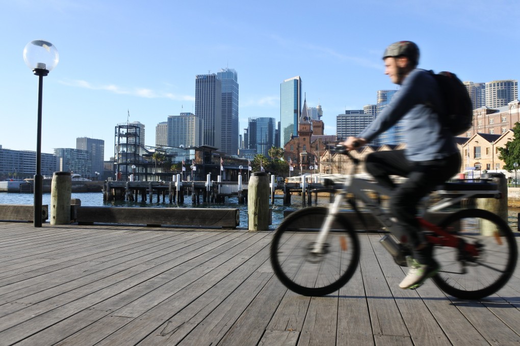 A man rides a bike along Circular Quay in Sydney in October 2016. The pandemic has hit cross-border investment in Australia’s commercial property market. Photo: Shutterstock