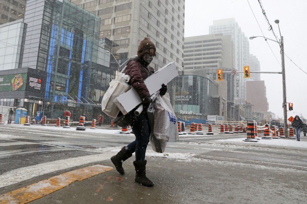 A shopper carries Christmas purchases in Toronto a day before coronavirus restrictions are reintroduced. Photo: Reuters