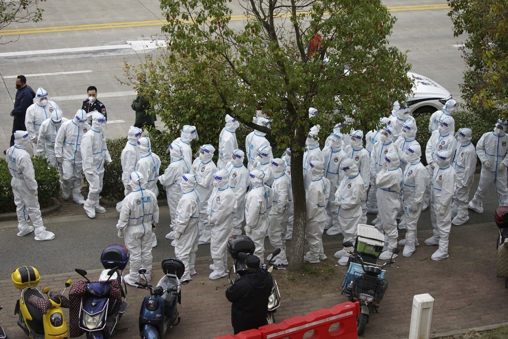 Security workers prepare to administer Covid-19 tests to workers in the car park at Pudong International Airport in Shanghai on Monday. Photo: AP