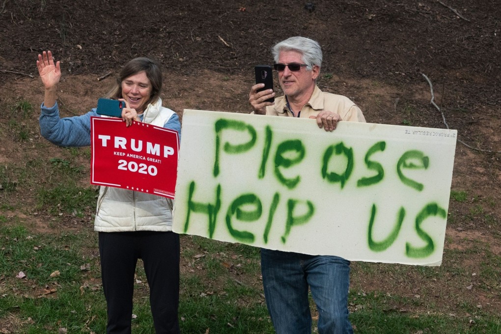 Supporters of US President Donald Trump hold signs and wave as his vehicle enters the Trump National Golf Club in Sterling, Virginia on November 22. Photo: AFP