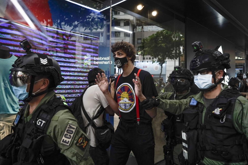 A men wearing a “Free Tibet” T-shirt is surrounded by police in Causeway Bay, Hong Kong, on China’s National Day on October 1. Photo: AP