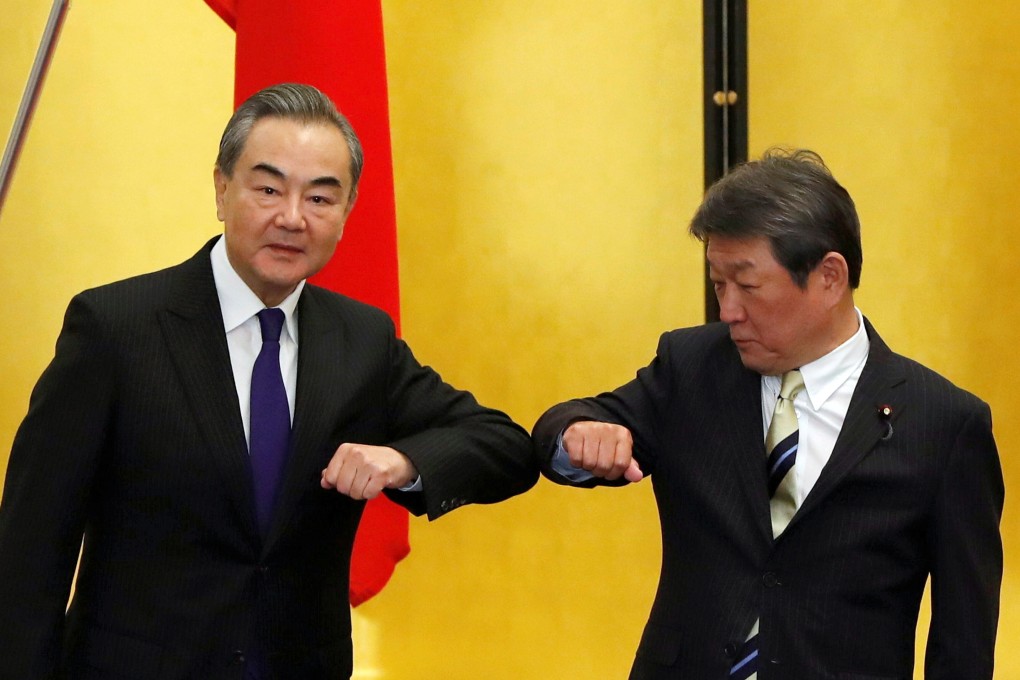 China’s Foreign Minister Wang Yi and his Japanese counterpart Toshimitsu Motegi bump elbows at the start of their talks in Tokyo on Tuesday. Photo: Reuters