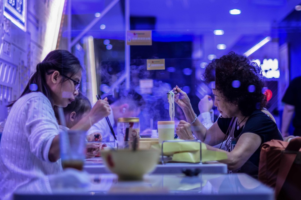 People eat at a restaurant with perspex shields between tables to help enable social distancing amid the Covid-19 pandemic in Hong Kong on Wednesday. Photo: AFP