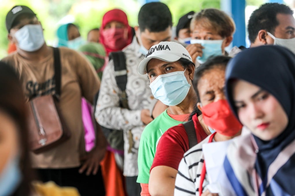 People queue to collect social assistance aid in Medan, North Sumatra, amid the pandemic. Photo: EPA-EFE