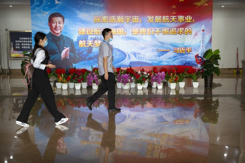 People walk past a billboard with a quote from Chinese President Xi Jinping in a building at the Wenchang Space Launch Site in Wenchang, Hainan province, on November 23, in the run-up to the successful launch of Chang’e 5. China is now a serious space contender. Photo: AP