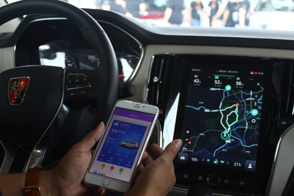 A driver demonstrates how to connect SAIC's Roewe RX5 sports-utility vehicle with his mobile phone using Alibaba's YunOS operating system on 6 July 2016. Photo: SCMP
