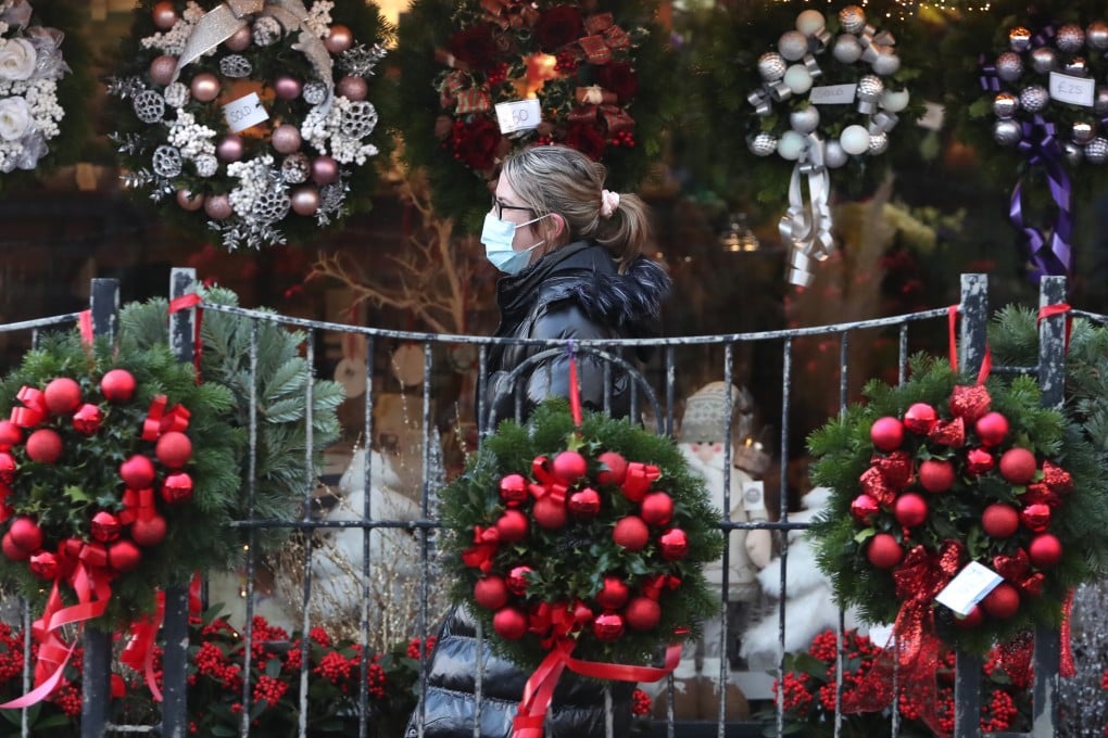 A woman walks past Christmas wreaths displayed for sale in Denny, Scotland. Photo: PA Wire/dpa