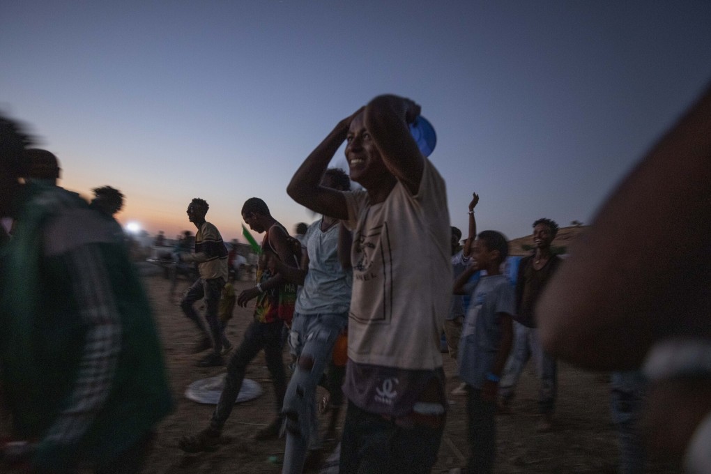 Tigray men run to receive cooked rice from a charity organisation at Umm Rakouba refugee camp in eastern Sudan’s Qadarif. Photo: AP