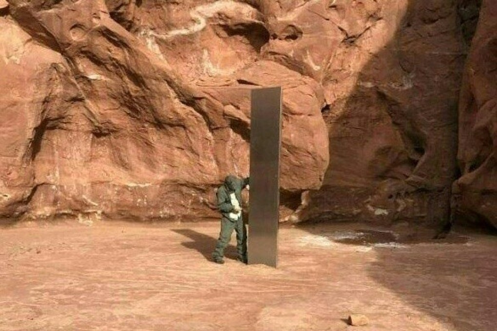 A worker inspects a metal monolith that was found installed in the ground in a remote area of red rock in Utah on November 18. Photo: Utah Department of Public Safety handout via AP