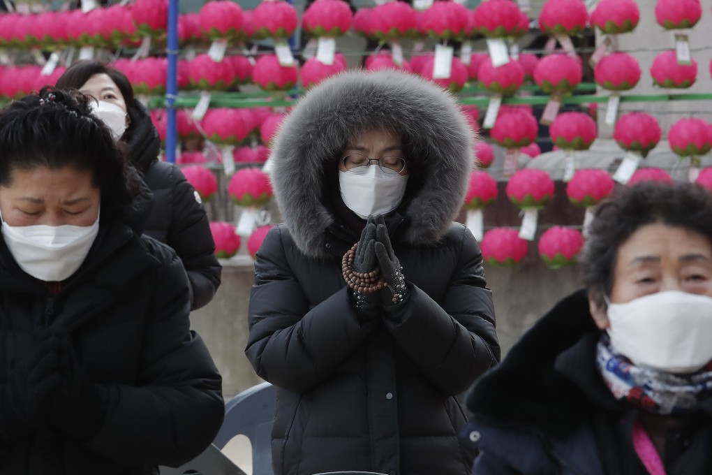 South Korean parents wearing face masks pray for their children’s success in the upcoming college entrance exam. Photo: AP