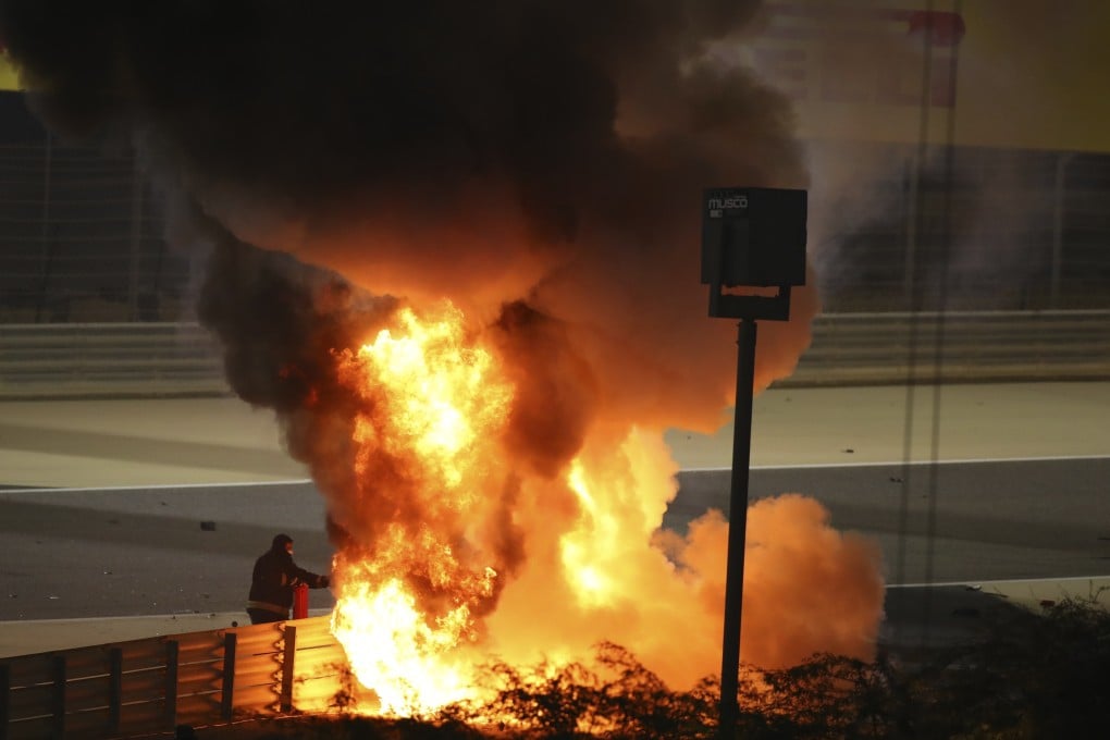 Staff extinguish flames from Haas driver Romain Grosjean of France's car after a crash during the F1 race in Bahrain on Sunday. Photo: AP